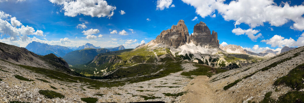 panorama of Tre Cime in the Dolomites, highlighting jagged cliffs and green meadows 