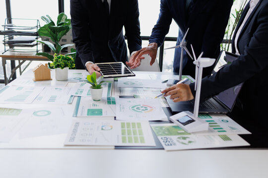 Business people collaborating on an esg meeting, planning green investments, and analyzing sustainable development reports
