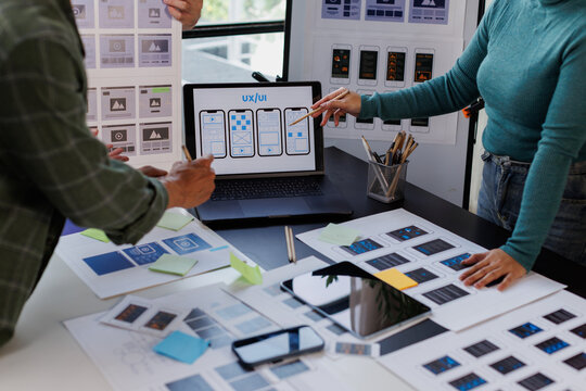 Ux ui designers collaborating on mobile application wireframes and user interface prototyping