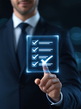 Executive hand selecting completed task on glowing checklist interface in dark office