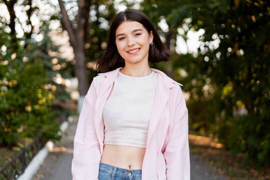 Young woman smiling outdoors enjoying nature and freedom