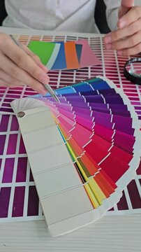 Selecting color shades for a design project at a table in a studio