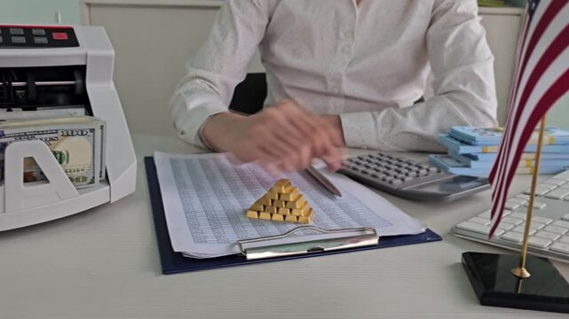Counting money and handling a gold pyramid in an office setting