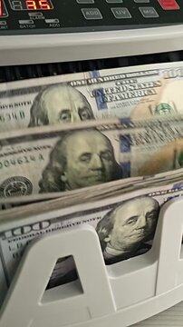 Counting cash in a bank with a machine in a busy city during the day