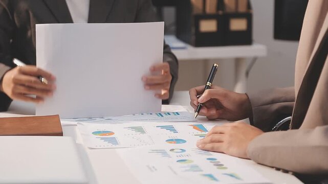 Business partnership coworkers using a tablet to analysis graph company financial budget report and cost work progress and planning for future in office room.