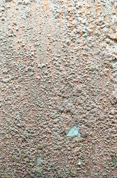 Close up of a textured wall with vertical lines and varied color tones