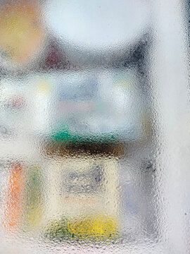 Abstract blurred view through frosted glass with colorful shapes and light