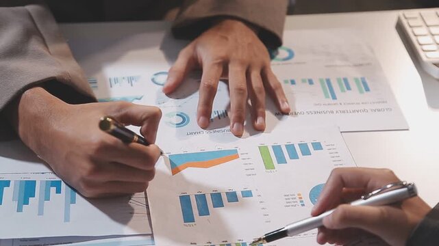 Business partnership coworkers using a tablet to analysis graph company financial budget report and cost work progress and planning for future in office room.