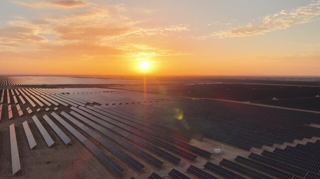 Stunning Sunset over Vast Solar Panel Farm in Remote Sandy Desert Landscape
