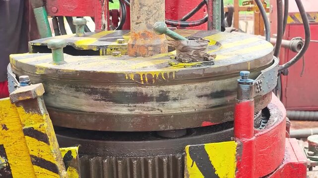 Operating power tong, torque machinery, to make connection of the drill pipe in the oil drilling operation. Heavy industrial working scene footage. close-up.