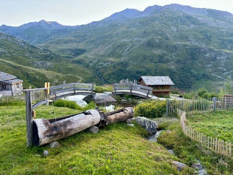 Alpine landscape with traditional wooden cabins and mountain spring