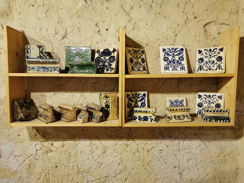 Antique pottery tiles and ceramic fragments displaying historical patterns
