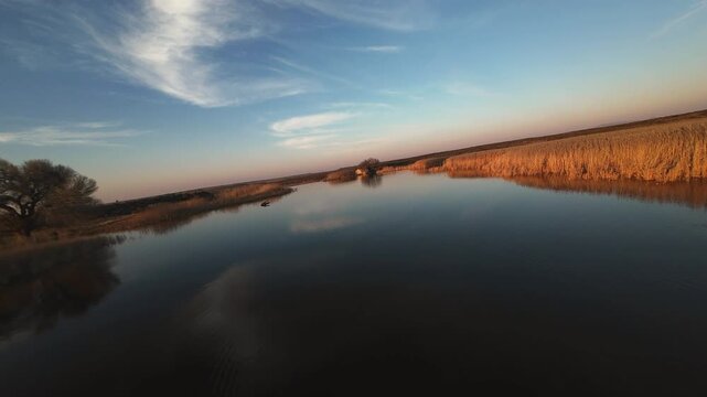 Sunset over a lake in the Karoo, surrounded by lush water reeds 