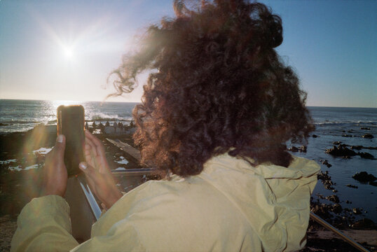 Woman with curly hair taking photos