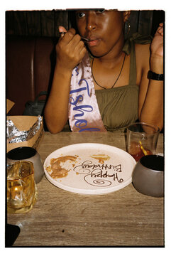Woman wearing a sash having dessert on her birthday