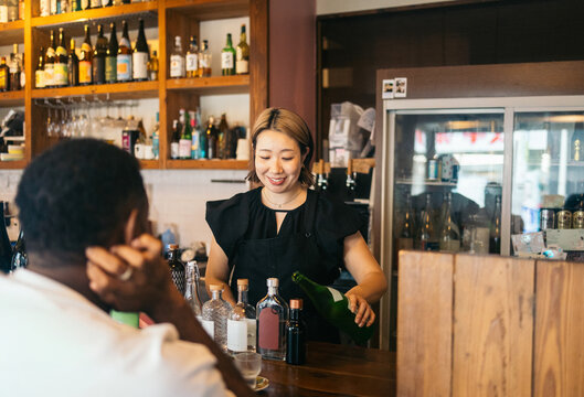 Bartender pouring sake for a customer
