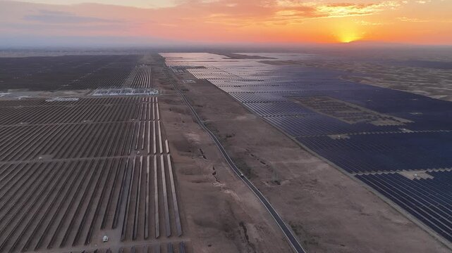 Stunning Sunset over Vast Solar Panel Farm in Remote Sandy Desert Landscape