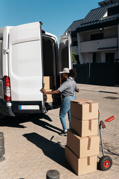 Woman courier delivering packages from delivery van