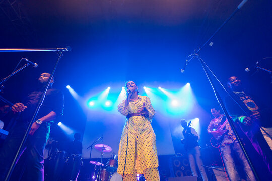 Female singer performing live music with band on stage