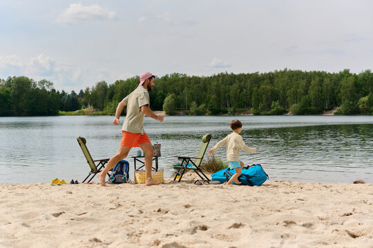 Father and Son Running on a Sandy Lakeshore