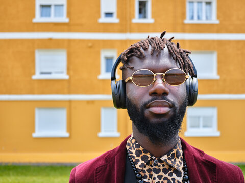 Black man with dreadlocks wearing headphones and sunglasses