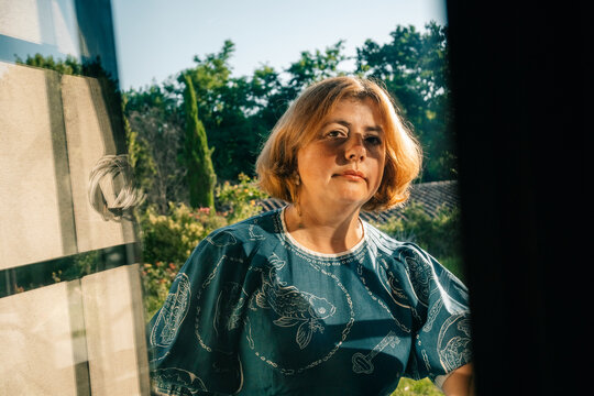 Woman Looking Outdoors From Inside a House on a Clear Day