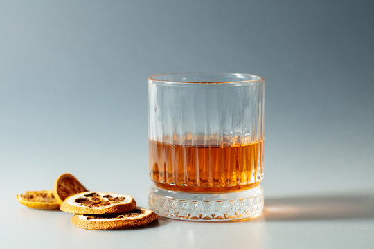 Whiskey in crystal glass with dried orange slices.