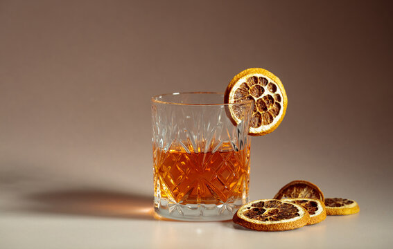 Refreshing rum cocktail garnished with dried orange slice.