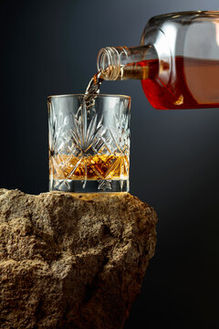 Whiskey is poured from a bottle into a glass.