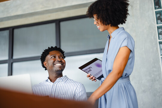 People Talk in an Office Setting With a Tablet in a Meeting Room