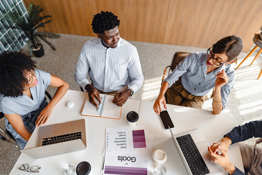 Team Members Discuss Ideas Around a Conference Table During Meeting