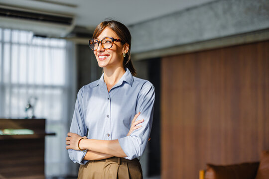 Woman Stands Smiling in an Office During the Day With Soft Light