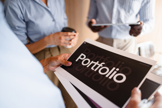 Group Discusses Portfolio During Meeting at Office
