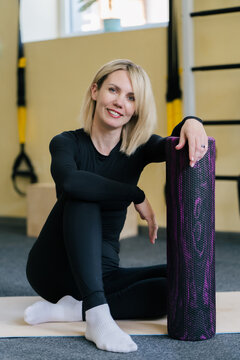 A woman with a roller in the gym.