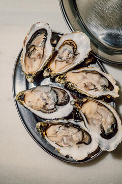 Platter of fresh raw open oysters on a marble counter