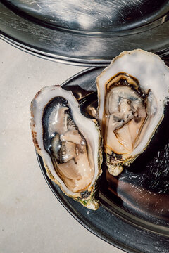 Fresh raw oysters served open on a vintage metal platter
