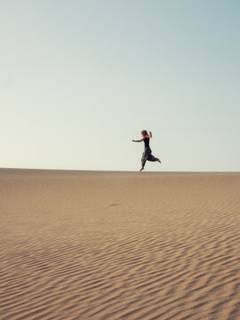 Person Jumping in Minimal Desert Landscape