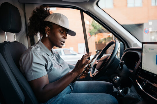 African american woman courier delivering packages using tablet