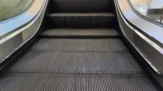 Escalator steps and glass balustrade in urban metro station