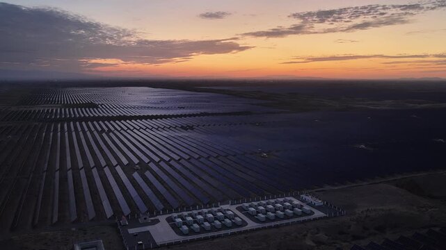 Stunning Sunset over Vast Solar Panel Farm in Remote Sandy Desert Landscape