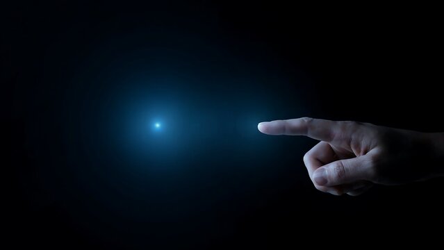 Hand pointing at a glowing blue light in darkness finger