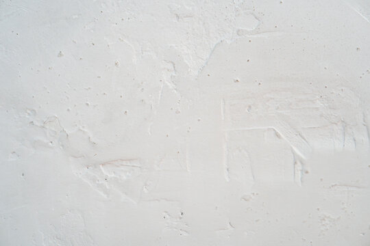 White plaster wall texture. Weathered rough stucco surface with trowel marks background.