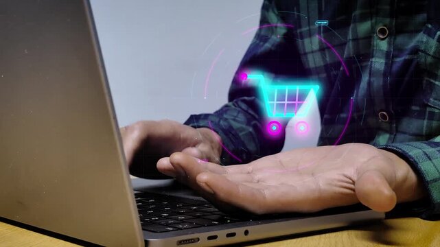Hand typing on laptop projecting digital hologram shopping cart. Online commerce retail purchase transaction processing over cyberspace internet network for cashless consumer payment solution.
