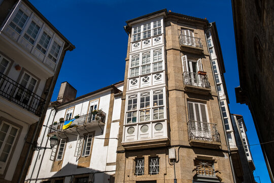 Traditional historic stone residential building with white wooden galerias balconies under a clear blue sky