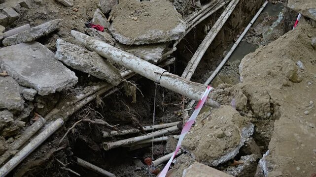 Construction site shows underground pipes and trenches at work location