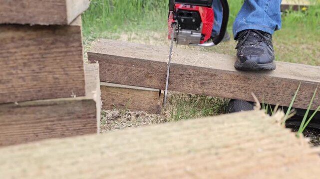 Cutting wood with a power saw in a backyard during daylight hours