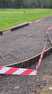 Road repair work shows uneven surface and barriers at park location