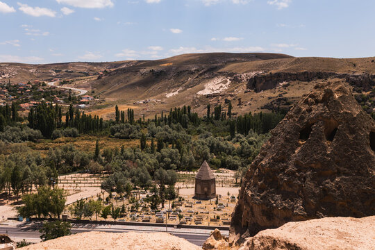 Scenic overview of Selime village valley and historical tomb surrounded by greenery in Cappadocia Turkey for tranquil cultural retreat.
