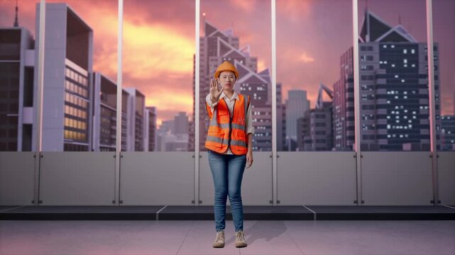 Full Body Of Asian Female Engineer With Safety Helmet Disapproving With No Hand Sign While Standing at Office with Panoramic City Skyline at Sunset