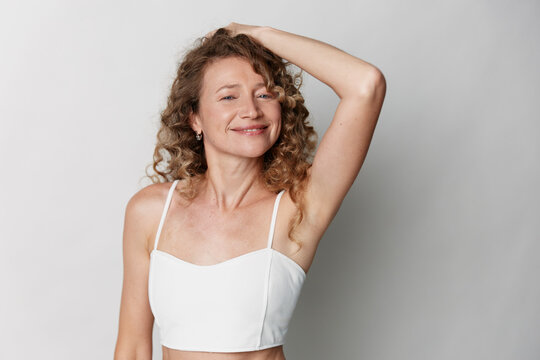 Authentic beauty of a middle aged woman with natural skin, relaxed smile, candid portrait conveying confidence, self acceptance and everyday elegance.